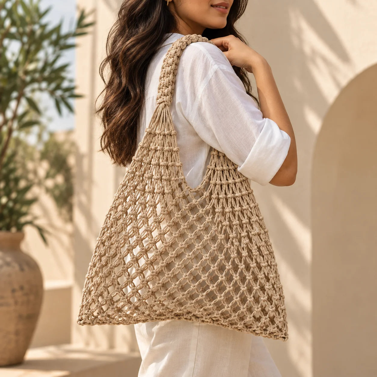 Beige mesh crochet bag with an open-weave knotted design and a relaxed, lightweight silhouette.