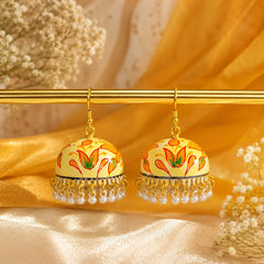 Ivory dome-shaped jhumka earrings with orange lotus floral design and pearl bead drops. Traditional handcrafted earrings displayed on a wooden surface with a handwritten tag.