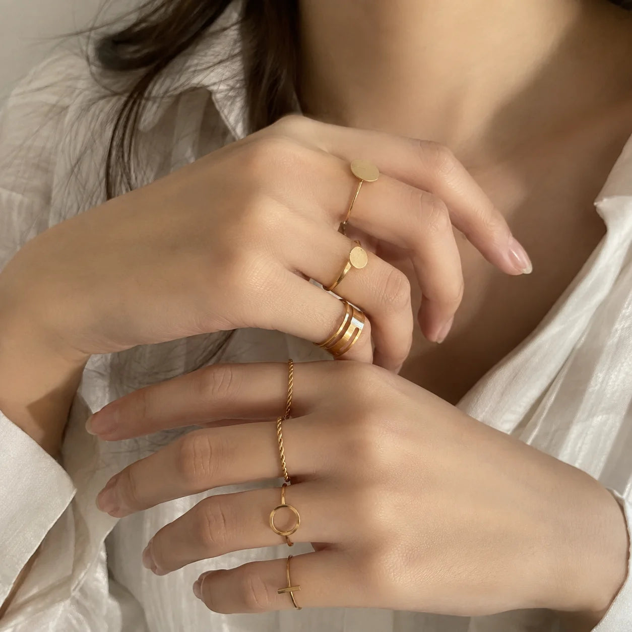 "Gold-tone ring stack
featuring a mix of smooth, twisted, and minimalist textured bands designed for versatile layering."