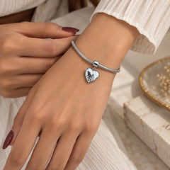 "Silver-tone chain
bracelet featuring a polished heart-shaped charm and an adjustable chain extender."