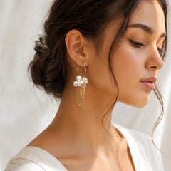 "Pair of gold-tone hoop
earrings adorned with clusters of lustrous white pearls and delicate dangling gold chains."