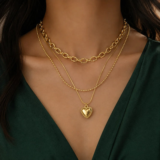 Multi layer gold necklace with puffed heart pendant and rope edge on snake chain