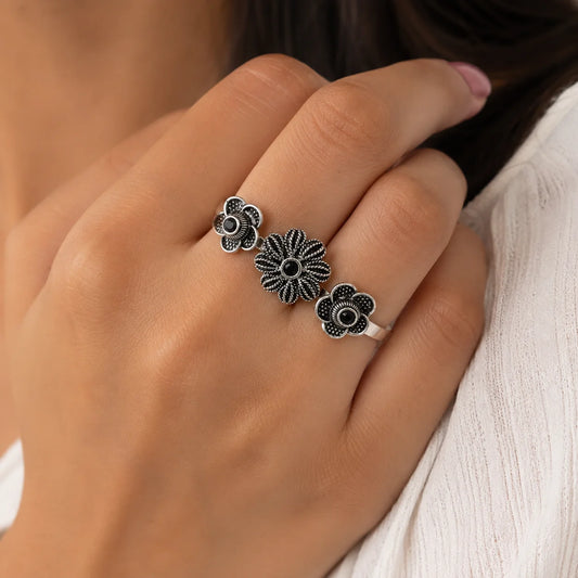 Oxidised silver double finger ring with three floral motifs and black stone centers