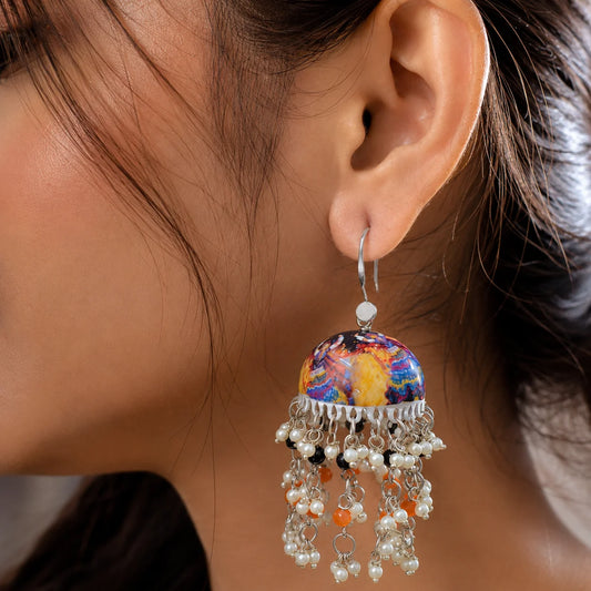 "Multicolour Meenakari jhumka
earrings with vibrant printed dome design, cascading pearl tassels, and orange and black bead accents, ideal for festive and ethnic wear."