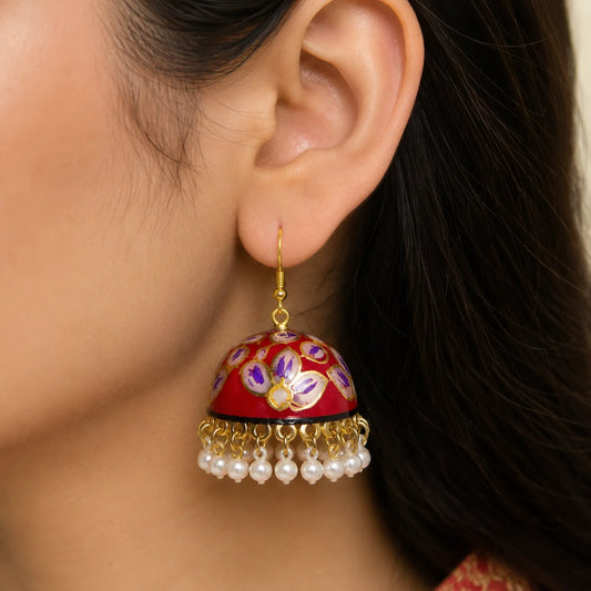 "Handcrafted red floral Meenakari jhumka
earrings featuring a hand-painted enamel dome with delicate white pearl bead drops. Traditional ethnic earrings for women, perfect for weddings, festive celebrations, family functions, and Indian ethnic wear."