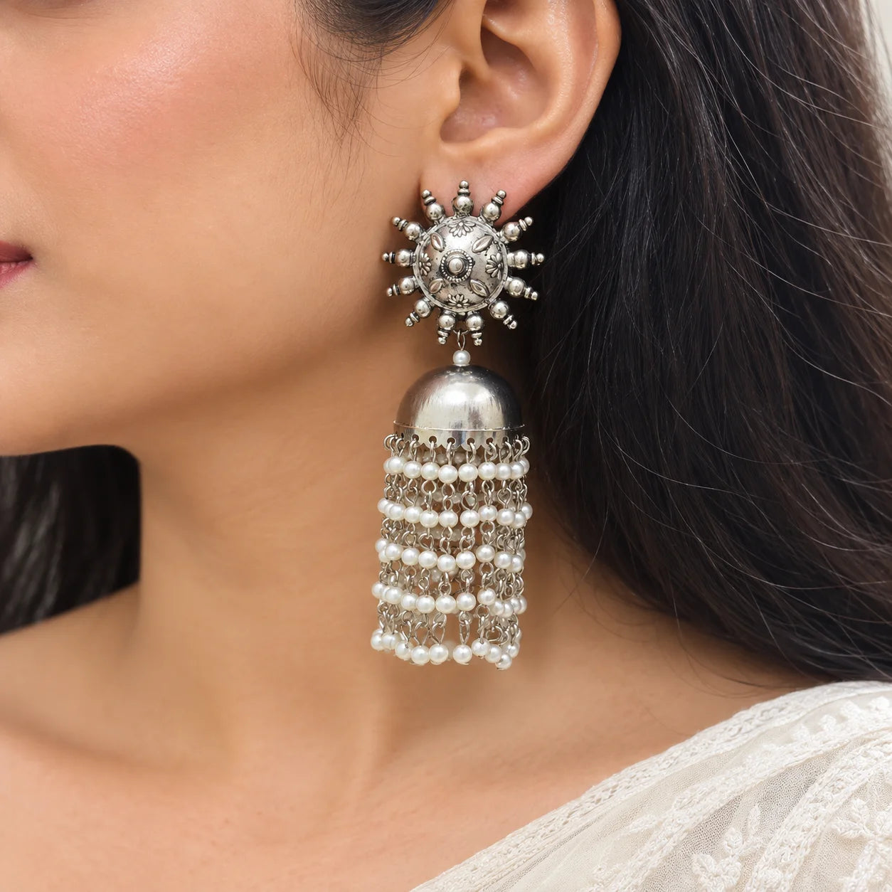 "Oxidised silver-tone statement
jhumka earrings with engraved floral stud design, dome-shaped detailing, and cascading pearl tassels. Traditional ethnic earrings for women, ideal for weddings, festive occasions, Navratri, Diwali, Haldi, Mehendi, and pairing with sarees, lehengas, kurtas, and Indo-western outfits."