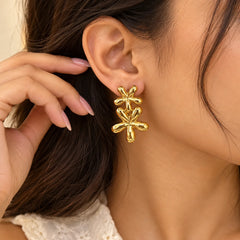 Gold double flower drop earrings with a polished finish and layered floral design.