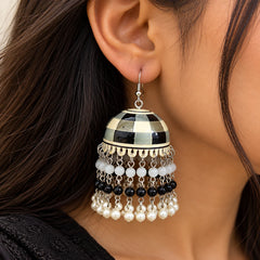 Black and white checkered dome jhumka earrings with layered black and white beads, silver-tone chains, and dangling pearl charms.