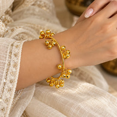 Gold-tone ghungroo bangle featuring a circular band with multiple clusters of dangling bell charms.