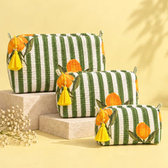 Quilted pouch with olive green and white stripes, orange floral prints, and a yellow tassel.
