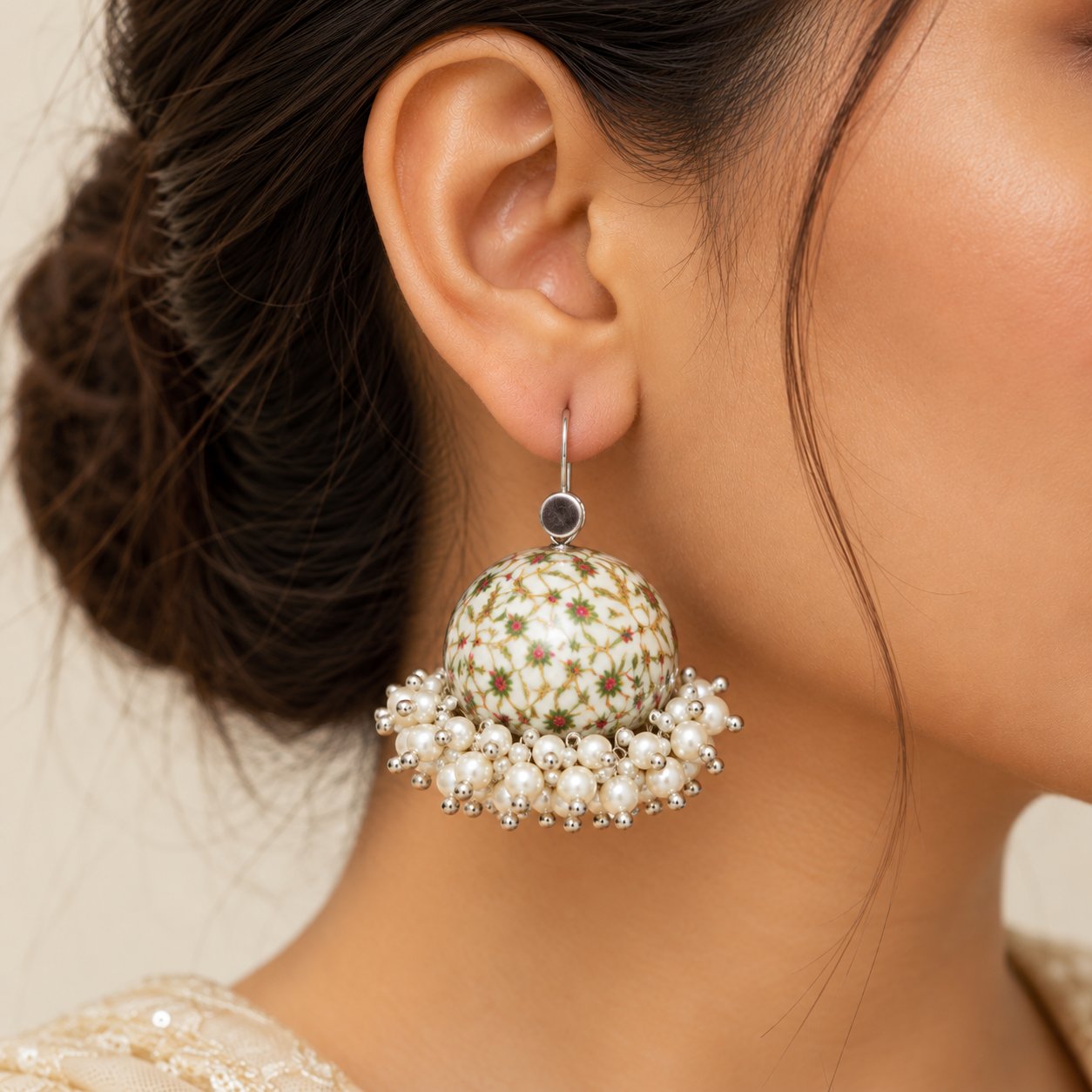 Cream white floral Meenakari jhumka earrings with delicate printed patterns, pearl cluster embellishments, and silver-tone detailing.