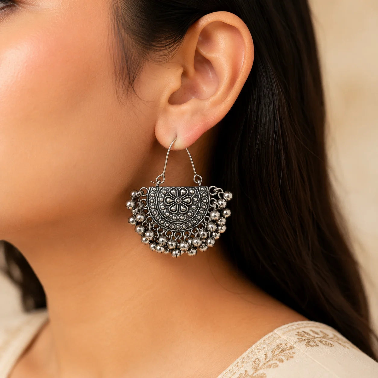 "Oxidised silver-tone floral
earrings featuring intricate embossed detailing and multiple dangling ghungroo accents in a traditional statement design for women."
