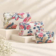 "Set of quilted fabric
pouches with a white base and colorful floral and botanical prints in pink, blue, green, coral, and yellow, featuring decorative tassel accents."