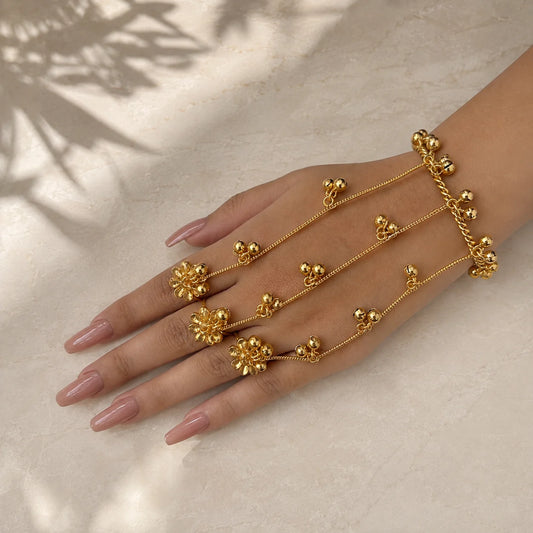 "Gold-tone adjustable haathphool
with finger rings, twisted hand chain, and dangling ghungroo charms. Traditional bridal hand jewellery for women, perfect for weddings and festive celebrations."