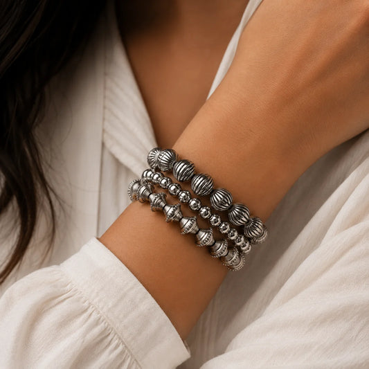 Handcrafted oxidised silver bracelet stack. Set of 3 beaded stretch bangles with carved details. Indo-western daily wear jewellery.
