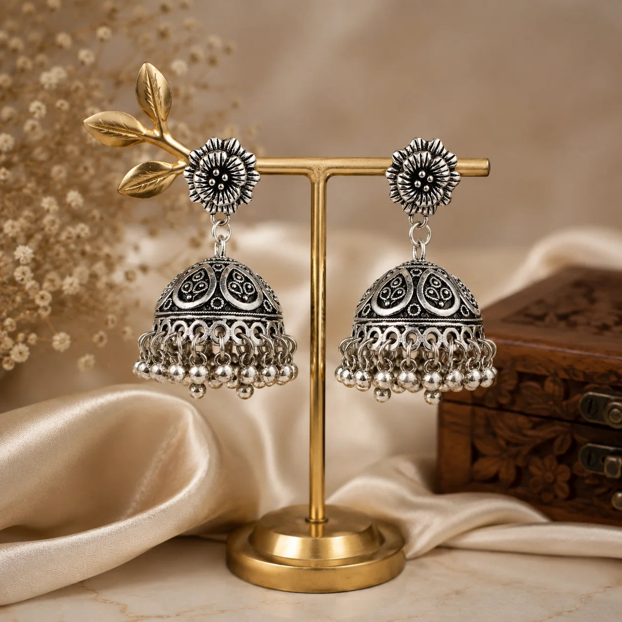 Oxidised silver dome jhumka earrings with ghungroo drops. Traditional bell-shaped earrings with leaf cutwork and floral top. Ethnic festive jewellery.