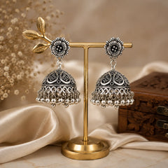 Oxidised silver dome jhumka earrings with ghungroo drops. Traditional bell-shaped earrings with leaf cutwork and floral top. Ethnic festive jewellery.