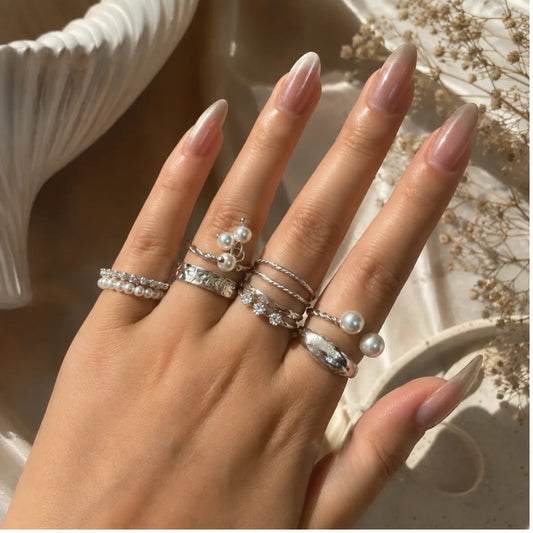"Silver-toned ring combo for
women featuring pearl accents, twisted bands, textured details and minimalist stackable designs."