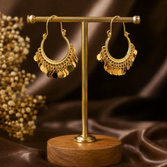 These gold tone bali earrings feature a wide U-hoop frame lined with multiple rows of hanging coin discs. Every step creates movement and sound of festive jewellery. High-shine gold plating with detailed wire work on the hoop. Wire hook closure makes them easy to wear. Large look but surprisingly lightweight because the discs are hollow.