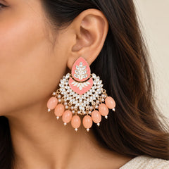 "Peach Chandbali statement
earrings with silver-toned floral leaf detailing, white pearl accents, and cascading soft pink beads arranged in an elegant chandelier-style design."