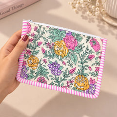 "Colorful floral quilted
pouch featuring pink, purple, yellow, and green flowers with a pink-and-white striped border and zip closure."