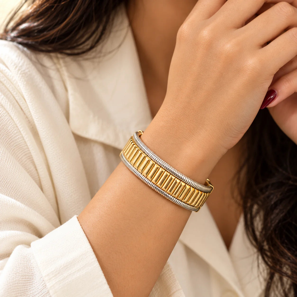 "Two-tone statement bracelet
featuring a wide gold-toned ribbed centre panel framed by sleek silver-toned textured bands, worn around the wrist."