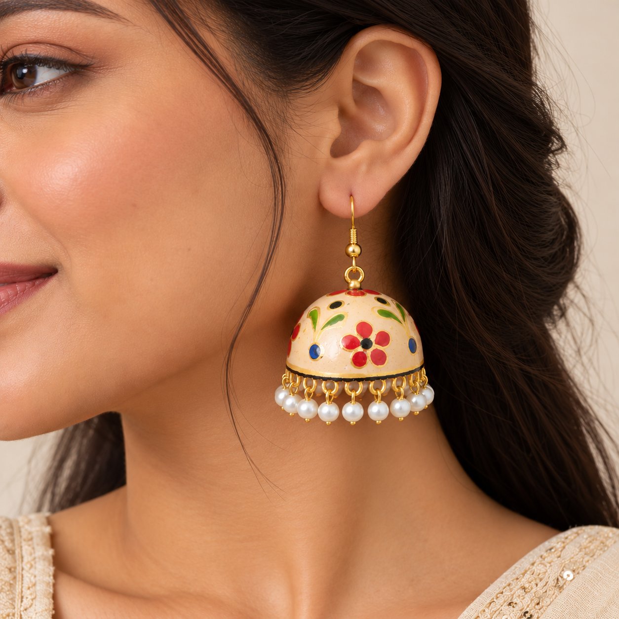 Cream Meenakari jhumka earring with multicolour floral motifs, gold-tone detailing, and dangling white pearl charms.