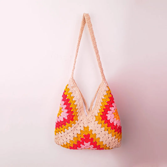 Beige crochet granny square bag with soft multicolor patchwork, handcrafted tote featuring earthy pastel tones and textured knit design.
