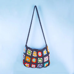 Black crochet granny square bag with multicolor patchwork design, handcrafted boho style shoulder bag with vibrant squares and textured knit pattern.
