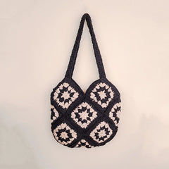 Handmade black and white crochet tote bag with granny square pattern, featuring long straps and a stylish monochrome design for everyday use.
