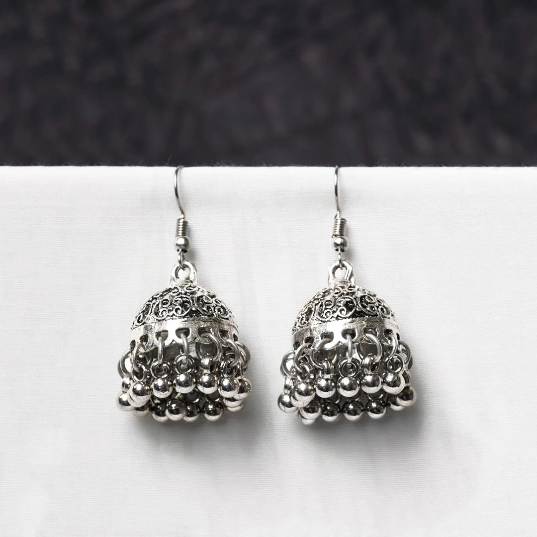 Oxidised jhumka earrings with intricate filigree dome detailing and ghungroo drops. Traditional bell-shaped design with rustic silver finish.

