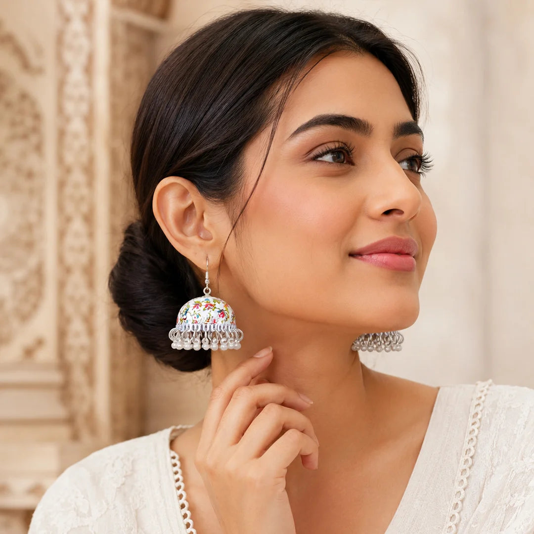 Ivory dome-shaped earrings with intricate multicolour floral patterns and delicate pearl drop detailing, designed in a vintage-inspired elegant style. Perfect for adding a soft, feminine charm to both casual and festive looks.
