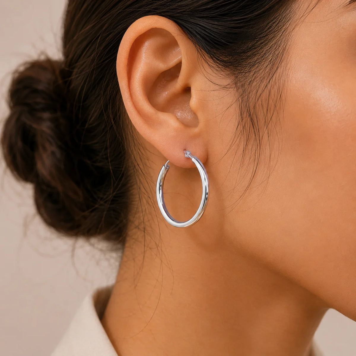 "Silver-tone hoop
 earrings featuring a sleek, classic circular design with a polished finish."
