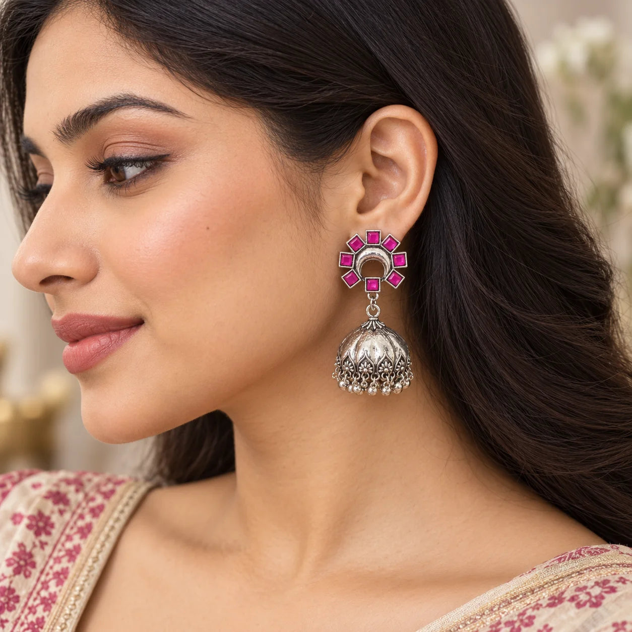 "Silver-tone jhumka earrings
 with vibrant pink enamel floral tops, intricately detailed dome-shaped designs, and delicate dangling bead accents."
