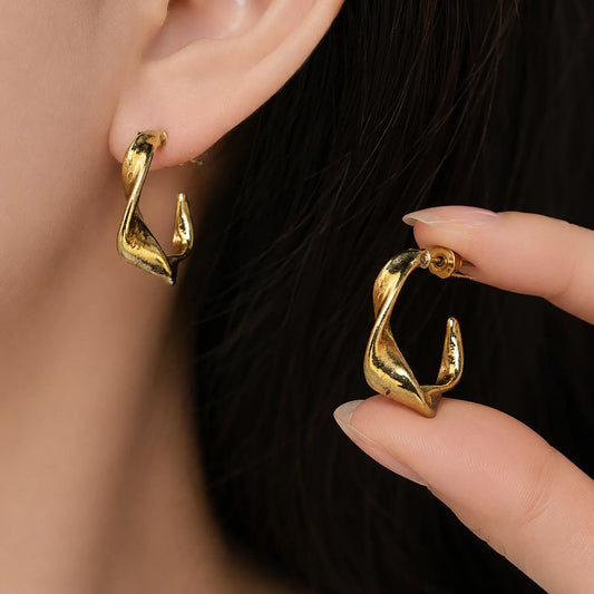Gold twisted C hoop earrings with high-shine polished finish. Modern wave sculpted shape with post-back closure. Western demi-fine earrings for daily and office wear.