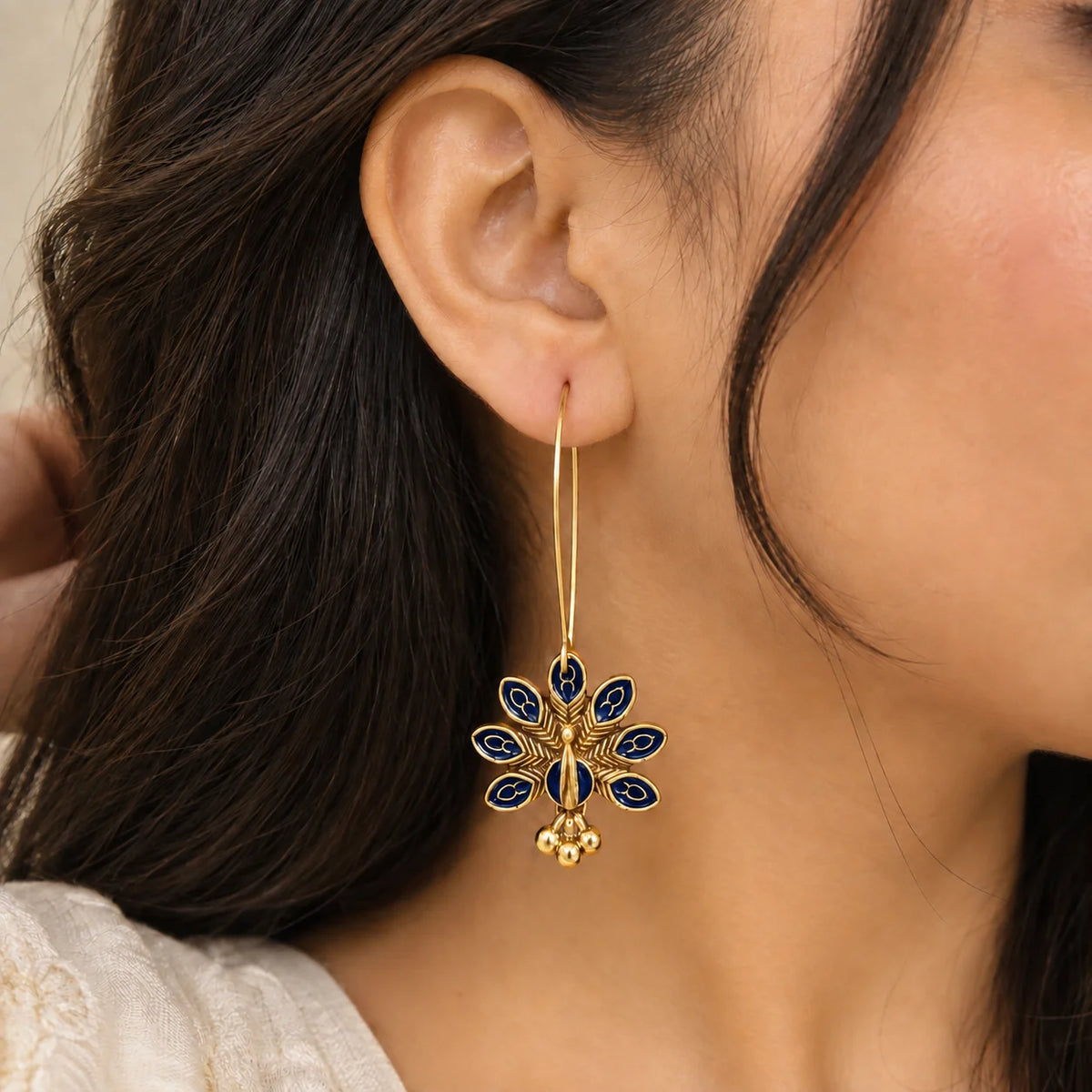 Navy Blue Peacock Hoop Earrings with intricate gold tone detailing and small dangling bead charms.
