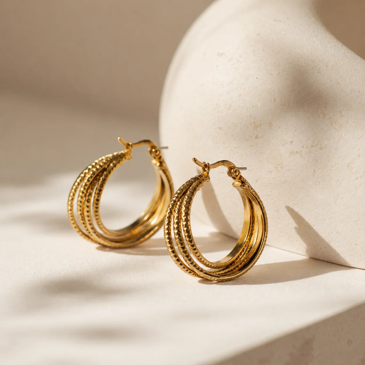 Gold triple layer hoop earrings with 18K gold plating. Textured outer hoop with lever-back closure. Demi-fine western statement earrings.
