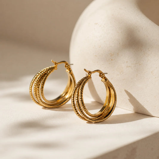 Gold triple layer hoop earrings with 18K gold plating. Textured outer hoop with lever-back closure. Demi-fine western statement earrings.
