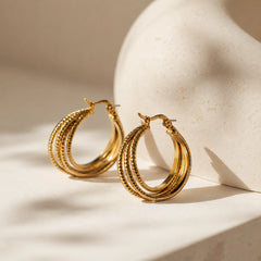 Gold triple layer hoop earrings with 18K gold plating. Textured outer hoop with lever-back closure. Demi-fine western statement earrings.
