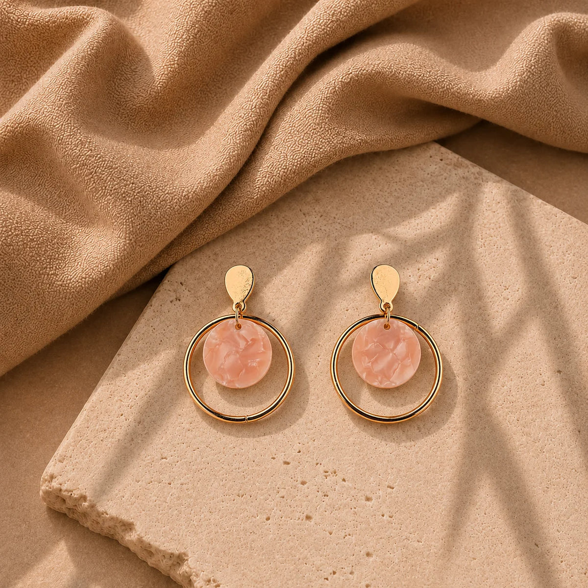 Gold circular drop earrings with pink acrylic disc. Hoop design with leaf stud top and post-back closure. Minimal western demi-fine earrings for women.
