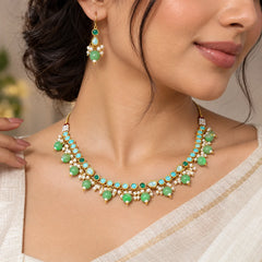 Sleek sea green kundan necklace set with green beads, pearl detailing, gold-toned accents, and matching earrings.
