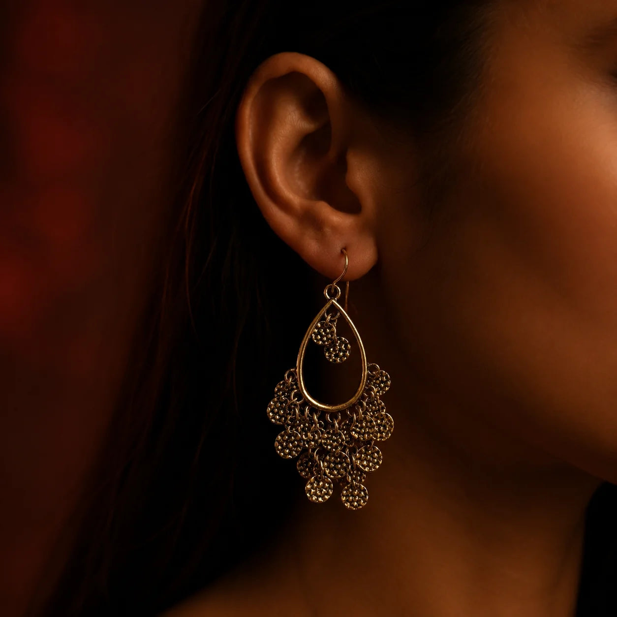 Antique gold teardrop dangle earrings with textured coin charms on wood background. Ethnic boho gold plated coin chandelier earrings with hook closure for women.

