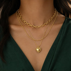Multi layer gold necklace with puffed heart pendant and rope edge on snake chain
