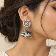 "Oxidised silver-tone 
jhumka earrings featuring intricate circular sunburst tops, detailed dome-shaped designs, and delicate dangling silver bead accents."
