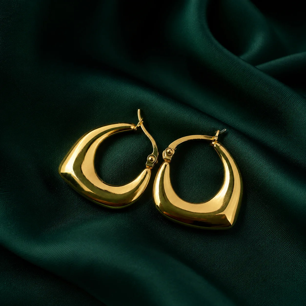 "Square Hoop Gold Earrings 
with a smooth sculptural design and polished finish, featuring a modern statement silhouette for everyday wear."
