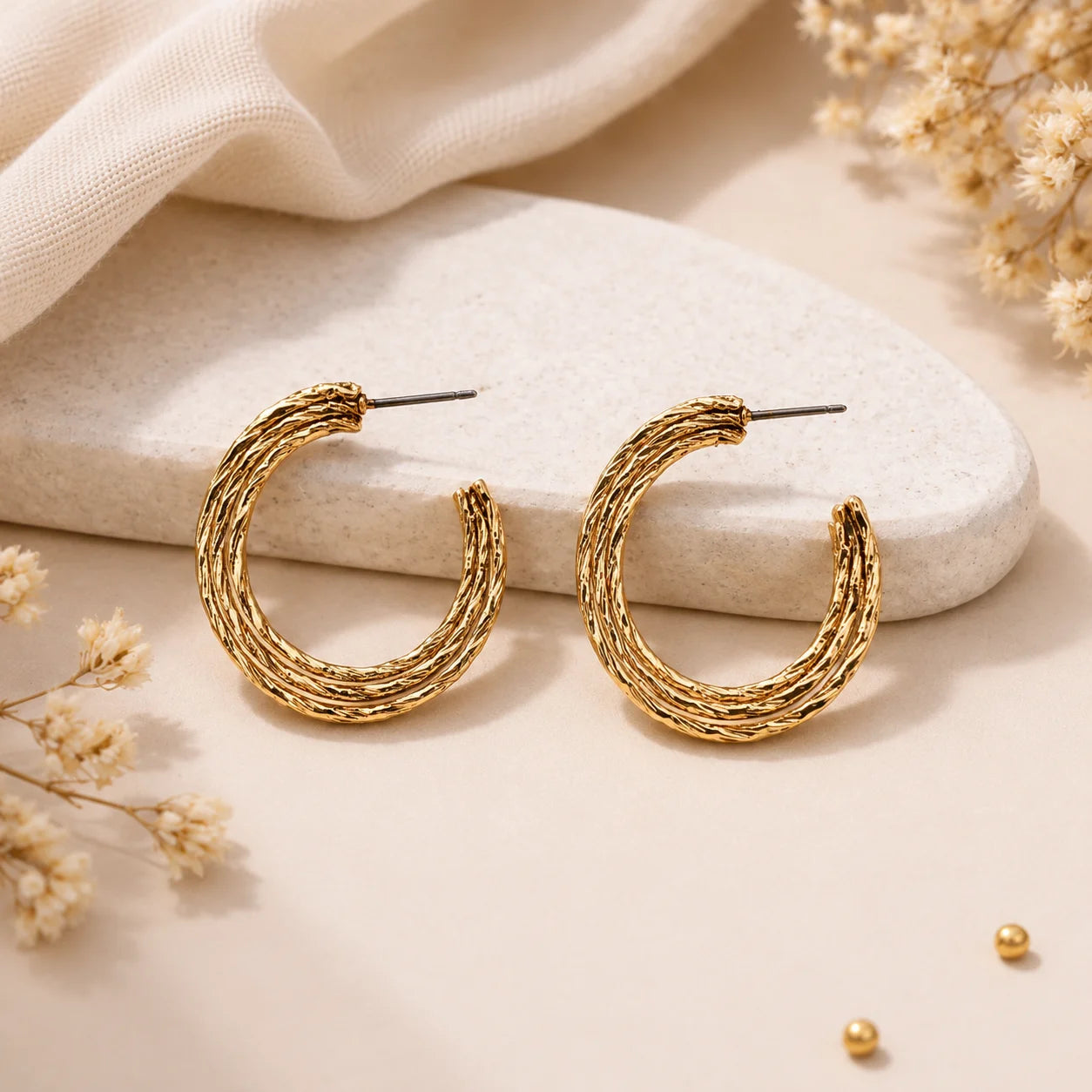 "Textured triple-layer gold hoop
 earrings featuring an organic
 hammered finish and 
polished gold-tone design.
 Lightweight statement hoop
 earrings for women, perfect
 for everyday wear parties,
 and festive occasions."
