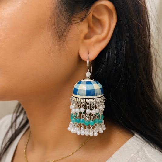 "Blue and offwhite handcrafted 
Meenakari jhumka earrings featuring a checkered enamel dome with pearl and bead tassels. Traditional ethnic earrings for women, perfect for weddings, festive celebrations, parties, and Indian ethnic wear."

