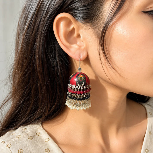 "Handcrafted red Meenakari jhumka
 earrings featuring a traditional Durga Maa-inspired hand-painted motif with pearl and multicolor bead tassels. Ethnic statement earrings for women, perfect for Navratri, Durga Puja, temple visits, festive celebrations, weddings, and traditional Indian wear."
