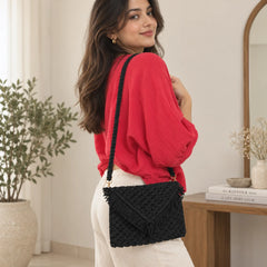 "Black macramé 
 bag featuring an intricate knotted weave, textured fringe detailing, and a long braided strap."

