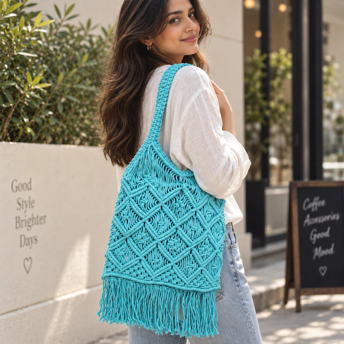"Blue macramé 
shoulder bag with an intricate geometric knotted pattern,  braided straps, and fringe detailing along the bottom."

